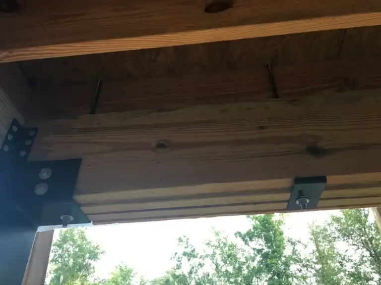 Underside of an elevated floor showing the post-to-beam connection
