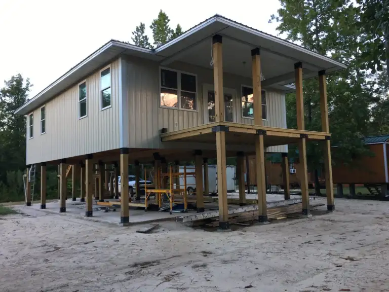 Elevated home with a wraparound porch built on posts held above the ground by Ty-Rite anchors