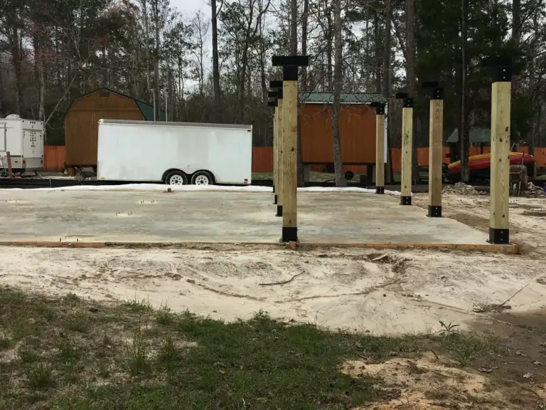 Posts standing on Ty-Rite anchors on a new slab, ready for framing